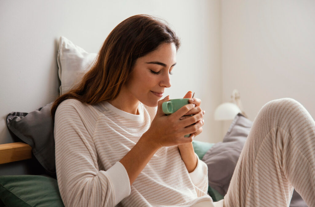 Person enjoying a relaxed morning routine with a notebook and a cup of tea